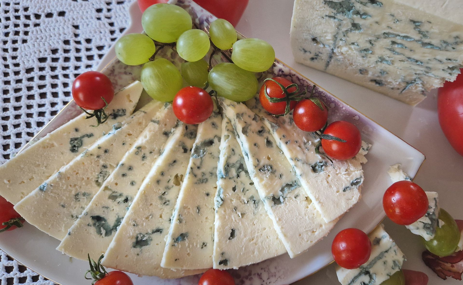 Ser Rokpol pokrojony w plastry, podany z winogronem i pomidorkami